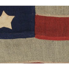 37 STARS IN A WHIMSICAL REPRESENTATION OF THE "GREAT STAR" PATTERN WITH A STAR BETWEEN EACH ARM, ON A HAND-SEWN FLAG IN A REMARKABLY TINY SCALE FOR THE PERIOD, PROBABLY 1867-1876, NEBRASKA STATEHOOD, AN EXCEPTIONAL EXAMPLE