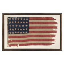 ENTIRELY HAND-SEWN 34 STAR FLAG OF THE CIVIL WAR PERIOD, WITH HAND-SEWN, SINGLE-APPLIQUED STARS AND ENDEARING WEAR FROM LONG-TERM USE, REFLECTS KANSAS STATEHOOD, 1861-1863