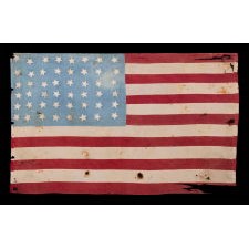 WWII LIBERATION FLAG WITH 48 HASTILY SEWN STARS ON A BEAUTIFUL, CORNFLOWER BLUE CANTON, FOUND BEHIND A CABINET IN A PARIS BASEMENT, MADE TO WELCOME U.S. TROOPS IN FRANCE FOLLOWING LIBERATION FROM THE GERMANS IN 1944, A WONDERFUL EXAMPLE WITH ENDEARING WEAR