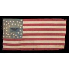 ANTIQUE AMERICAN FLAG OF THE CIVIL WAR PERIOD, WITH THE RARE PRESENCE OF A COPPERPLATE-PRINTED EAGLE IN THE CANTON, SET WITHIN A FRACTURED WREATH PATTERN OF 34 STARS AND WITH ITS CANTON RESTING ON THE WAR STRIPE; REFLECTS THE PERIOD OF KANSAS STATEHOOD, 1861-63