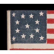 13 STARS IN A MEDALLION PATTERN ON AN ANTIQUE AMERICAN PARADE FLAG MADE BETWEEN APPROXIMATELY 1910 AND THE 1926 SESQUECENTENNIAL OF AMERICAN INDEPENDENCE