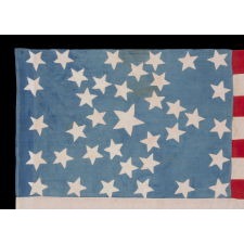 ANTIQUE AMERICAN FLAG WITH 37 STARS ON A CORNFLOWER BLUE CANTON, ARRANGED IN A UNIQUE “GREAT STAR” OR “GREAT LUMINARY” CONFIGURATION, INCORPORATED INTO A RECTANGULAR MEDALLION; A HOMEMADE EXAMPLE, MADE DURING THE ERA OF AMERICAN RECONSTRUCTION; REFLECTS NEBRASKA STATEHOOD, 1867-1876