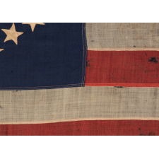 35 STAR ANTIQUE AMERICAN FLAG OF THE CIVIL WAR PERIOD, IN A DESIRABLE SMALL SCALE AMONG ITS COUNTERPARTS, WITH A RARE AND BEAUTIFUL "SNOWBALL MEDALLION"; LIKELY MADE IN BALTIMORE BY SAILMAKER JABEZ LOANE; REFLECTS THE TIME WHEN WEST VIRGINIA WAS THE MOST RECENT STATE TO JOIN THE UNION, 1863-1865