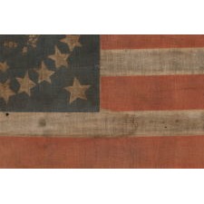 EXTRAORDINARILY RARE ANTIQUE AMERICAN FLAG, WITH A FEDERAL EAGLE SURROUNDED BY 32 STARS, THE ONLY KNOWN EXAMPLE OF ITS KIND; TWO OF THE STARS FAR SMALLER THAN THE REST, LIKELY TO REFLECT WESTERN TERRITORIES; MADE IN THE DECADE BEFORE, OR WITHIN THE PERIOD, WHEN MINNESOTA JOINED THE UNION AS THE 32nd STATE; A ONE-YEAR FLAG, ACCURATE FOR JUST NINE MONTHS, 1858-59