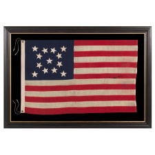 13 STAR ANTIQUE AMERICAN FLAG, MADE IN THE ERA OF THE 1876 CENTENNIAL, WITH HAND-SEWN STARS IN A MEDALLION CONFIGURATION, IN A WONDERFUL, SMALL SCALE AMONG ITS COUNTERPARTS OF THE PERIOD