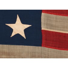 ENTIRELY HAND-SEWN, 13 STAR AMERICAN FLAG, A U.S. NAVY SMALL BOAT ENSIGN MARKED “No. 12,” WITH A 3-2-3-2-3 ARRANGEMENT OF ESPECIALLY LARGE AND ATTRACTIVE STARS, LIKELY MADE DURING THE CLOSING YEARS OF THE CIVIL WAR, 1864-1865