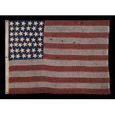 44 STAR ANTIQUE AMERICAN FLAG, WITH GREAT FOLK CHARACTERISTICS THAT INCLUDES A NARROW, VERTICALLY-ORIENTED CANTON AND ESPECIALLY LARGE STARS, ORIENTED IN ALL DIRECTIONS, THE ARMS OF WHICH ARE NECESSARILY INTERTWINED; WYOMING STATEHOOD, 1890-1896
