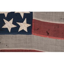 44 STAR ANTIQUE AMERICAN FLAG, WITH GREAT FOLK CHARACTERISTICS THAT INCLUDES A NARROW, VERTICALLY-ORIENTED CANTON AND EXPECIALLY LARGE STARS, ORIENTED IN ALL DIRECTIONS, THE ARMS OF WHICH ARE NECESSARILY INTERTWINED; WYOMING STATEHOOD, 1890-1896