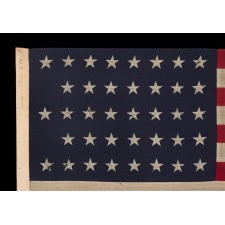 38 STAR ANTIQUE AMERICAN FLAG WITH A NOTCHED CONFIGURATION, MADE BY THE U.S. BUNTING COMPANY IN LOWELL, MASSACHUSETTS, SIGNED "THROCKMORTON," REFLECTS THE ERA OF COLORADO STATEHOOD, CIRCA 1876-1889
