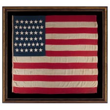 38 STAR ANTIQUE AMERICAN FLAG OF THE INDIAN WARS PERIOD, A U.S. ARMY REGULATION BATTLE FLAG, ENTIRELY HAND-SEWN, 1876-1889, SIGNED "VARRELL." MADE IN THE ERA WHEN COLORADO WAS THE MOST RECENT STATE TO JOIN THE UNION