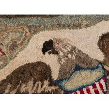 WOOL HOOKED RUG WITH A CANTED, SPREAD-WINGED, FEDERAL EAGLE, ON A MODELED GROUND WITH TWO STARS, A PRAIRIE POINT BORDER, AND A CHENILLE FRINGE, circa 1835 -1865