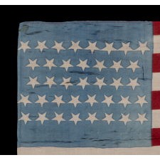 38 STAR ANTIQUE AMERICAN PARADE FLAG IN A SQUARE, BATTLE FLAG STYLE, PRINTED ON SILK, WITH BEAUTIFUL CORNFLOWER BLUE AND SCARLET RED COLORATION; POSSIBLY SOLD AS A KERCHIEF / BANDANNA; UNIQUE AMONG KNOWN EXAMPLES, PROBABLY MADE FOR THE 1888 CAMPAIGN OF BENJAMIN HARRISON; REFLECTS COLORADO STATEHOOD, 1876-1889