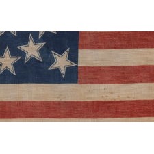 13 HALOED STARS IN A MEDALLION CONFIGURATION, ON AN EXCEPTIONALLY RARE ANTIQUE AMERICAN FLAG MADE FOR THE 1876 CENTENNIAL OF AMERICAN INDEPENDENCE