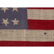 34 STARS WITH "DANCING" OR "TUMBLING" ORIENTATION, ON AN ANTIQUE AMERICAN FLAG WITH EXTRAORDINARY COLORS, PRESS-DYED ON WOOL BUNTING, LIKELY PRODUCED FOR USE AS MILITARY CAMP COLORS, CIVIL WAR PERIOD, 1861-1863, REFLECTS THE ADDITION OF KANSAS TO THE UNION AS A FREE STATE