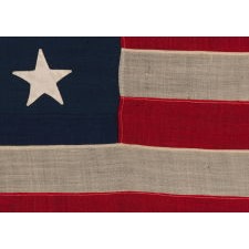 13 STAR ANTIQUE AMERICAN FLAG, MADE IN THE ERA OF THE 1876 CENTENNIAL, WITH HAND-SEWN STARS IN A MEDALLION CONFIGURATION, IN A DESIRABLE SCALE AMONG ITS COUNTERPARTS OF THE PERIOD
