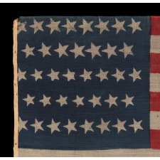 38 CRUDE STARS IN VARIOUS SIZES, ON A CLAMP-DYED, WOOL, ANTIQUE AMERICAN FLAG, MADE BY THE HORSTMANN BROTHERS IN PHILADELPHIA, ALMOST CERTAINLY FOR DISPLAY AT THE 1876 CENTENNIAL EXPOSITION; A VERY RARE AND ENDEARINGLY VISUAL EXAMPLE, REFLECTS COLORADO STATEHOOD