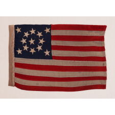 13 STAR ANTIQUE AMERICAN FLAG WITH A MEDALLION CONFIGURATION OF STARS; A TINY EXAMPLE AMONG ITS COUNTERPARTS WITH SEWN CONSTRUCTION, MADE circa 1895-1926, EXHIBITED AT THE MUSEUM OF THE AMERICAN REVOLUTION, JUNE-JULY 2019