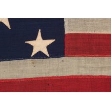 ENTIRELY HAND-SEWN, 13 STAR AMERICAN FLAG, WITH A 3-2-3-2-3 ARRANGEMENT OF STARS, U.S. NAVY SMALL BOAT ENSIGN, LIKELY MADE DURING THE CLOSING YEARS OF THE CIVIL WAR, 1864-1865