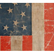 38 STAR ANTIQUE AMERICAN FLAG WITH AN EXCEPTIONALLY RARE “GREAT-STAR-IN-A-WREATH” CONFIGURATION AND ENDEARING WEAR FROM OBVIOUS LONG-TERM USE, 1876-1889, REFLECTS THE ADDITION OF COLORADO TO THE UNION