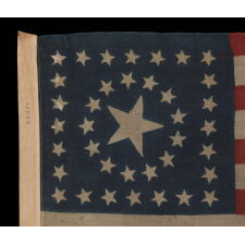 38 STARS IN A RARE CIRCLE-IN-A-SQUARE MEDALLION WITH A HUGE CENTER STAR, ON AN ANTIQUE AMERICAN FLAG MADE BY HORSTMANN BROS. IN PHILADELPHIA FOR THE 1876 CENTENNIAL INTERNATIONAL EXPOSITION, REFLECTS THE ADDITION OF COLORADO TO THE UNION