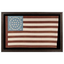 38 STAR ANTIQUE AMERICAN FLAG WITH AN EXTREMELY RARE DOUBLE-WREATH CONFIGURATION THAT FEATURES A SQUARE OF FOUR STARS BOTH INSIDE AND OUT, ON A BEAUTIFUL, CORNFLOWER BLUE CANON THAT RESTS ON THE BLOOD STRIPE, HAVING A WIDE, OXBLOOD RED HOIST AND STRIPES OF THE SAME UNUSUAL COLOR; A STRIKING, HOMEMADE FLAG, FOUND IN WEST VIRGINIA AND WITH VERBAL HISTORY AS TO HAVING BEEN MADE THERE; REFLECTS THE PERIOD OF COLORADO STATEHOOD, 1876-1889