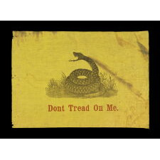 ONE OF THE TWO EARLIEST KNOWN FLAGS IN THE DESIGN PRESENTED BY CHRISTOPHER GADSDEN OF SOUTH CAROLINA, FORMER MEMBER OF THE SONS OF LIBERTY, DELEGATE TO THE CONTINANTAL CONGRESS, AND CHAIR OF THE MARINE COMMITTEE, SUGGESTING IT BECOME THE “STANDARD OF THE COMMANDER IN CHIEF OF THE CONTINENTAL U.S. NAVY,” BETTER KNOWN AS THE "GADSDEN FLAG;" PRINTED ON GLAZED, SAFFRON YELLOW COTTON, ATTRIBUTED TO PRINTER JOHN M. EASTERBY OF NEW YORK AND SOUTH CAROLINA, circa 1860 (POSSIBLY PRIOR)