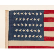 38 CANTED STARS IN STAGGERED ROWS, ON A CLAMP-DYED, WOOL, ANTIQUE AMERICAN FLAG MADE BY THE HORSTMANN BROTHERS IN PHILADELPHIA, ALMOST CERTAINLY FOR DISPLAY AT THE 1876 CENTENNIAL EXPOSITION; A VERY RARE EXAMPLE WITH STRONG COLORS AND GREAT TEXTURE; REFLECTS COLORADO STATEHOOD
