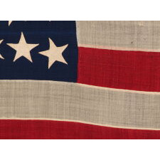 ENTIRELY HAND-SEWN, 38 STAR, ANTIQUE AMERICAN FLAG OF THE INDIAN WARS PERIOD, WITH A SQUARISH PROFILE AND A CANTON THAT IS TALLER THAN IT IS WIDE, SIMILAR TO U.S. INFANTRY AND ARTILLERY BATTLE FLAGS, AND WITH AN ESPECIALLY GRAPHIC PRESENTATIONOF STARS; MADE IN THE ERA WHEN COLORADO WAS THE MOST RECENT STATE TO JOIN THE UNION, 1876-1889