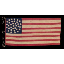 34 STAR ANTIQUE AMERICAN FLAG OF THE CIVIL WAR PERIOD (1861-63), IN A TINY SCALE AMONG PIECED-AND-SEWN FLAGS OF THE PERIOD, WITH A TRIPLE-WREATH CONFIGURATION, AN ELONGATED FORMAT, AND ENTIRELY HAND-SEWN; FOUND WITH A LETTER FROM JOHN W. RUDE OF THE 2ND KENTUCKY VETERAN VOLUNTEER CAVALRY (UNION)