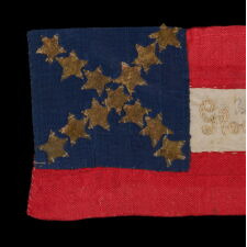 CONFEDERATE BIBLE FLAG IN THE FIRST NATIONAL DESIGN, WITH 13 GILT FOIL STARS, MADE OF SILK AND ENTIRELY HAND-SEWN, WITH ITS STARS CONFIGURED IN AN EXCEPTIONALLY RARE SALTIRE, AND EMBROIDERED TEXT THAT READS: “GLORIE ET LIBERTE” (GLORY & LIBERTY); ACCOMPANIED BY AN 1863 LETTER, WRITTEN BY A WOMAN IN NEW ORLEANS TO A CONFEDERATE SOLDIER IN VICKSBURG, MISSISSIPPI