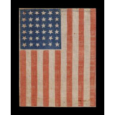 36 STAR ANTIQUE AMERICAN PARADE FLAG, WITH STARS THAT ALTERNATE IN THEIR VERTICAL POSITION FROM COLUMN TO COLUMN AND ROW-TO-ROW, PRINTED ON AN ESPECIALLY INTERESTING LENGTH OF COARSE COTTON WITH A CRUDE WEAVE THAT RESULTS IN A VISUALLY COMPELLING APPEARANCE; CIVIL WAR ERA, NEVADA STATEHOOD, 1864-1867