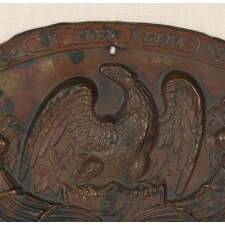 ESPECIALLY LARGE EARLY AMERICAN MILITARY HAT PLATE, MADE OF PRESSED COPPER, WITH AN EAGLE PERCHED ON A FEDERAL SHIELD, FLANKED BY CORNUCOPIA, AND THE MOTTO “NE PLUS ULTRA” (THE ZENITH OR HIGH WATER MARK); PRESSED BRASS WITH PAINTED SURFACE, circa 1825-1850 OR POSSIBLY PRIOR