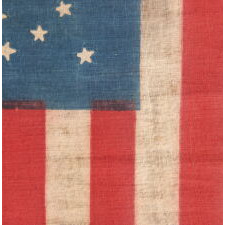43 STAR ANTIQUE AMERICAN PARADE FLAG, ONE OF JUST THREE KNOWN EXAMPLES AND THE ONLY ONE WITH A DYNAMIC STAR PATTERN; ONE OF THE RAREST STAR COUNTS AMONG SURVIVING AMERICAN FLAGS OF THE 19TH CENTURY; REFLECTS THE ADDITION OF IDAHO AS THE 43RD STATE IN 1890
