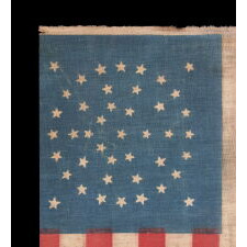 43 STAR ANTIQUE AMERICAN PARADE FLAG, ONE OF JUST THREE KNOWN EXAMPLES AND THE ONLY ONE WITH A DYNAMIC STAR PATTERN; ONE OF THE RAREST STAR COUNTS AMONG SURVIVING AMERICAN FLAGS OF THE 19TH CENTURY; REFLECTS THE ADDITION OF IDAHO AS THE 43RD STATE IN 1890