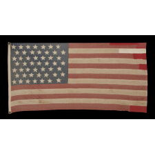 49 STARS ON A VINTAGE, HOMEMADE AMERICAN FLAG WITH ITS CANTON RESTING ON THE WAR STRIPE AND NUMEROUS REPAIRS FORM OBVIOUS LONG-TERM USE; REFLECTS THE ADDITION OF ALASKA IN 1959; OFFICIAL FOR JUST ONE YEAR