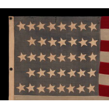 38 STARS IN A "NOTCHED" PATTERN, ON AN ANTIQUE AMERICAN FLAG WITH A DUSTY BLUE CANTON; LEAVES SPACE FOR MORE WESTERN TERRITORIES THAT HAD NOT YET JOINED THE UNION; REFLECTS COLORADO STATEHOOD, 1876-1889