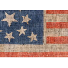 13 STARS IN A MEDALLION PATTERN ON AN ANTIQUE AMERICAN PARADE FLAG MADE SOMETIME BETWEEN THE CIVIL WAR (1861-1865) AND THE 1876 CENTENNIAL OF AMERICAN INDEPENDENCE, WITH A BEAUTIFUL, CORNFLOWER BLUE CANTON AND IN AN UNUSUALLY LARGE SIZE AMONG ITS COUNTERPARTS