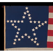 CIVIL WAR PERIOD ANTIQUE AMERICAN FLAG WITH 35 STARS IN A “GREAT STAR” OR “GREAT LUMINARY” PATTERN, A VERY RARE VARIETY WITH AN OPEN, LONE STAR PROFILE, LACKING STARS INSIDE OR BEYOND THE ARRANGEMENT; MADE circa 1863-65, REFLECTS THE ADMISSION OF WEST VIRGINIA TO THE UNION AS A FREE STATE, ANNEXED FROM VIRGINIA JUST 10 DAYS BEFORE THE BATTLE OF GETTYSBURG; PROBABLY WAR-CARRIED