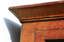 PENNSYLVANIA DUTCH CUPBOARD IN BITTERSWEET ORANGE PAINT, WITH VINEAGR DECORATION, ON TURNED FEET, FOUND IN READING, PA, 1840-1870