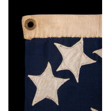 VERY RARE CONFEDERATE NAVAL ENSIGN IN THE FIRST NATIONAL (STARS & BARS) PATTERN, IN AN EXTRAORDINARY, SMALL SIZE, WITH 11 WHIMSICAL, SINGLE-APPLIQUÉD STARS AND A CURIOUSLY WIDE RED BAR, ENTIRELY HAND-SEWN, MADE BETWEEN MAY - NOVEMBER OF 1861: