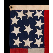 VERY RARE CONFEDERATE NAVAL ENSIGN IN THE FIRST NATIONAL (STARS & BARS) PATTERN, IN AN EXTRAORDINARY, SMALL SIZE, WITH 11 WHIMSICAL, SINGLE-APPLIQUÉD STARS AND A CURIOUSLY WIDE RED BAR, ENTIRELY HAND-SEWN, MADE BETWEEN MAY - NOVEMBER OF 1861: