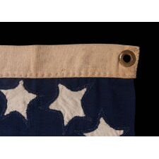 VERY RARE CONFEDERATE NAVAL ENSIGN IN THE FIRST NATIONAL (STARS & BARS) PATTERN, IN AN EXTRAORDINARY, SMALL SIZE, WITH 11 WHIMSICAL, SINGLE-APPLIQUÉD STARS AND A CURIOUSLY WIDE RED BAR, ENTIRELY HAND-SEWN, MADE BETWEEN MAY - NOVEMBER OF 1861: