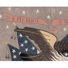 SAILOR’S SOUVENIR EMBROIDERY FROM THE WITH A FLYING, WARLIKE EAGLE SUPERIMPOSED ON A CANTED FEDERAL SHIELD & CROSSED AMERICAN FLAGS, BENEATH A STREAMER WITH THE LATIN MOTTO “E PLURIBUS UNUM,” INTERSPERSED WITH 13 STARS, circa 1890-1910