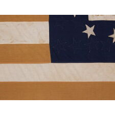 13 STARS IN A LOPSIDED, OVAL WREATH, SURROUNDING A FANCIFULLY HAND-PAINTED EAGLE, SIGNED “J.L. SEARING,” WITH A GARLAND-LADEN STREAMER THAT READS: "UNITED WE STAND, DIVIDED WE FALL", ON A HOMEMADE, ANTIQUE AMERICAN FLAG, WITH 44 STARS ON THE OPPOSING SIDE, MADE IN LOST SPRINGS KANSAS [MARION CO.], FOR A VETERAN OF BOTH THE MEXICAN AND CIVIL WARS WHO SETTLED THERE; REFLECTS THE PERIOD WHEN WYOMING WAS THE MOST RECENT STATE TO JOIN THE UNION, 1890-1896