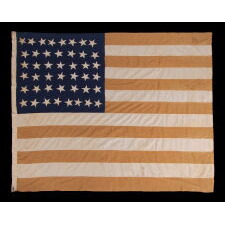 13 STARS IN A LOPSIDED, OVAL WREATH, SURROUNDING A HAND-PAINTED EAGLE, WITH A GARLAND-LADEN STREAMER THAT READS: "UNITED WE STAND, DIVIDED WE FALL", ON A HOMEMADE, ANTIQUE AMERICAN FLAG WITH 44 STARS ON THE OPPOSING SIDE; MADE IN KANSAS, LINKED TO TWO ILLINOIS, UNION ARMY VETERANS; REFLECTS THE PERIOD WHEN WYOMING WAS THE MOST RECENT STATE TO JOIN THE UNION, 1890-1896