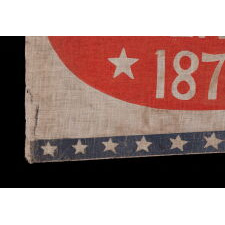 SWALLOW-TAILED PARADE FLAG / PENNANT WITH “1776 CENTENNIAL 1876” SET WITHIN A SUNBURNT, RED-ORANGE, EGG-SHAPED WINDOW, WITHIN A BLUE BORDER WITH 37 STARS; AN EXTREMELY RARE EXAMPLE, MADE TO CELEBRATE THE 100-YEAR ANNIVERSARY OF AMERICAN INDEPENDENCE