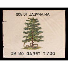 ONE OF A TINY GROUP OF SURVIVING ANTIQUE AMERICAN FLAGS THAT INCLUDES A RATTLESNAKE, IN A VARIANT OF CLOSELY RELATED DESIGNS FLOWN BY THE COLONIAL MASSACHUSETTS NAVY (1775-1776) & POSSIBLY BY THE PENNSYLVANIA NAVY ON THE DELAWARE RIVER (1775 – 1778), ALL WITH A GREEN PINE TREE AS THE CENTRAL DEVICE ON A WHITE FIELD; THIS EXAMPLE MADE circa 1910-1926, WITH A RATTLESNAKE COILED ABOUT ITS BASE AND TWO SLOGANS: “AN APPEAL TO GOD” & “DON’T TREAD ON ME”