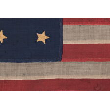 U.S. NAVY SMALL BOAT ENSIGN WITH 13 STARS IN THE 4-5-4 PATTERN, A VERY EARLY EXAMPLE, MADE circa 1835-1850’s, ENTIRELY HAND-SEWN AND IN A TINY SCALE AMONG ITS COUNTERPARTS