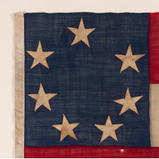 WAR-PERIOD CONFEDERATE FLAG IN THE FIRST NATIONAL PATTERN (a.k.a., STARS & BARS) WITH A CRUDE WREATH OF 7 STARS, IN A SMALL SCALE AMONG ITS COUNTERPARTS, PROBABLY MADE FOR USE AS A MILITARY FLANK MARKER OR CAMP COLORS, CIRCA 1861