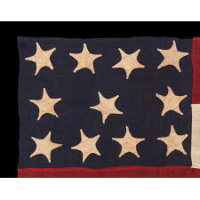 WAR-PERIOD CONFEDERATE FLAG IN THE FIRST NATIONAL PATTERN (a.k.a., STARS & BARS), IN A TINY SIZE, WITH AN ELONGATED PROFILE, AND 11 STARS ARRANGED IN AN UNUSUAL, RECTANGULAR MEDALLION; ENTIRELY HAND-SEWN, MADE BETWEEN MAY - NOVEMBER, 1861